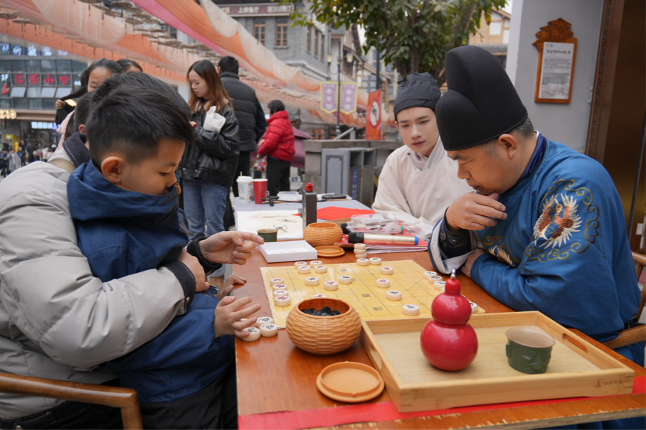 十八梯景区内npc与游客进行下象棋互动（央广网发 周长江 摄）