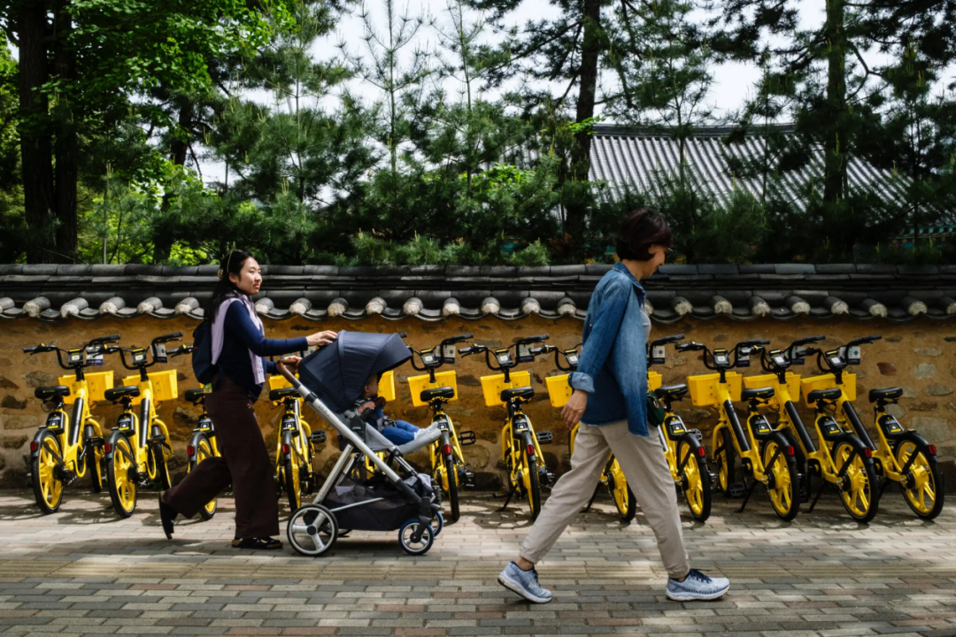 △首尔街头,一对父母推着婴儿车散步。韩国总和生育率时隔四年重回0.8区间,实现连续两年反弹。(图源:《纽约时报》)