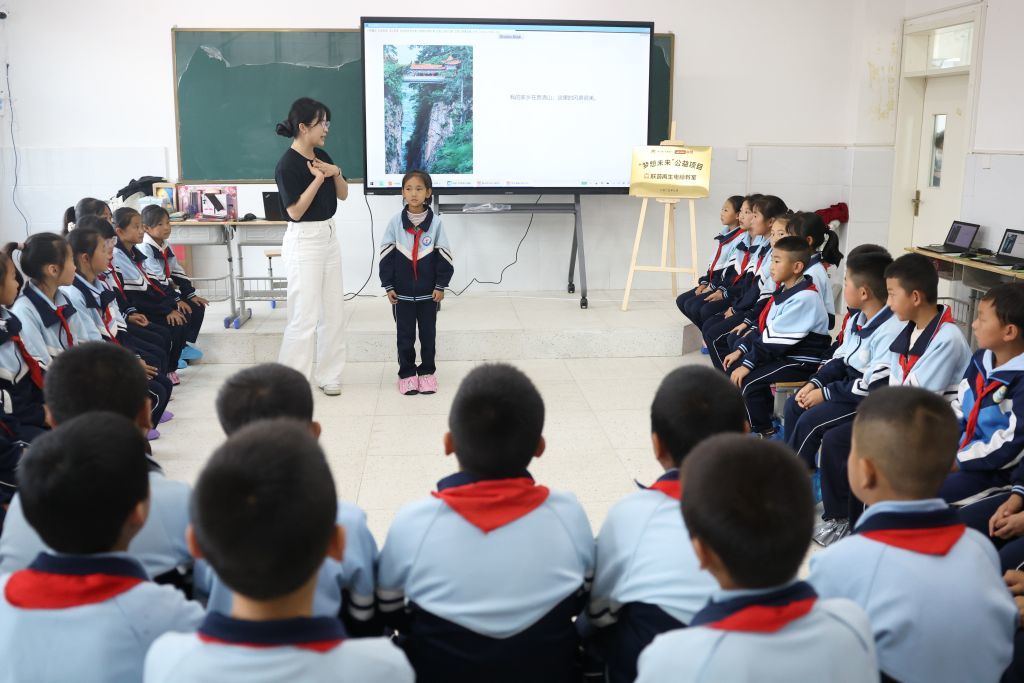 2025年9月10日,甘肃省定西市漳县盐川学校的学生在AI课堂上与联想志愿者互动。新华社记者 陈斌 摄