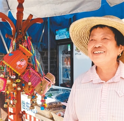 村民袁大荣在家门口售卖农特产品,吸引很多外地游客光顾。