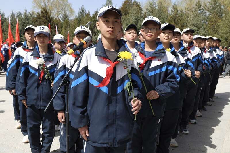 4月3日上午11时许,位于宁夏固原市彭阳县古城镇的任山河烈士陵园内,学生们手持花朵,有序排队等候祭奠英烈。中青报·中青网记者 焦敏龙/摄