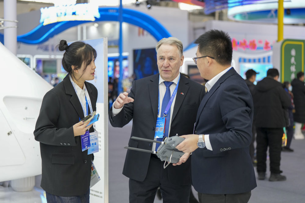 1月6日,在2026哈尔滨国际冰雪经济博览会现场,参会嘉宾(中)在了解一款工业无人机的参数和性能。新华社记者 王松 摄