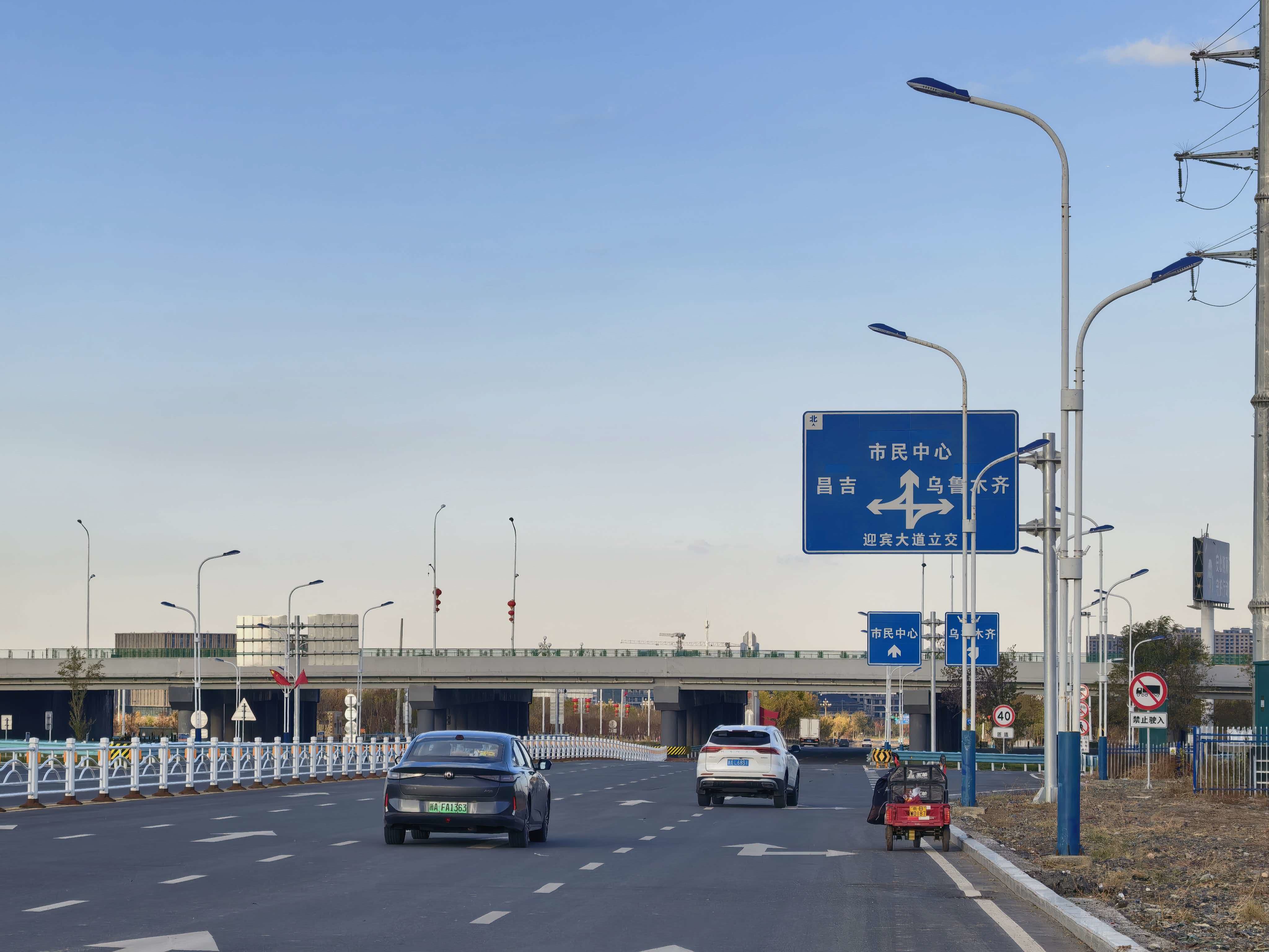 10月25日,在十二师初心路互通现场,车辆沿着新建的匝道依次平稳汇入乌昌快速路。冯晓玲摄.jpg