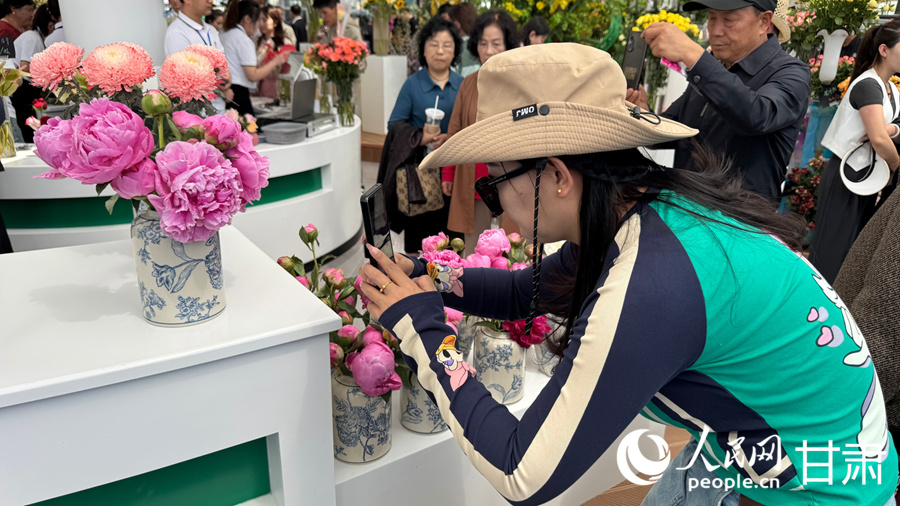 游客在临夏市牡丹产业园花卉艺术中心内赏花游玩。人民网记者 焦隆摄