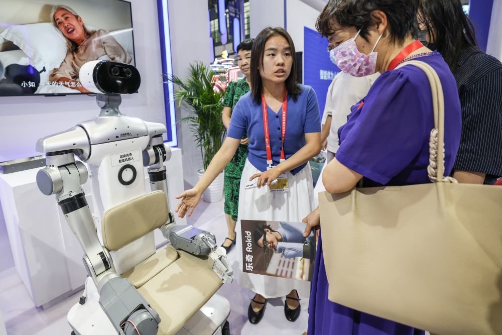 ↑ 4月13日，参观者在第六届消博会现场了解具身智能机器人。新华社记者 张丽芸 摄