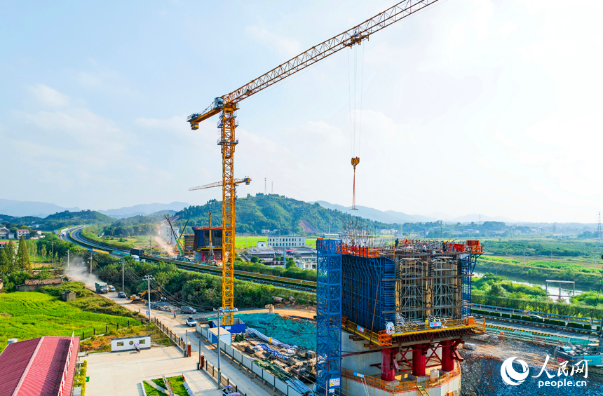 萍乡市上栗县金山镇的栗水河特大桥建设现场,塔吊林立,工业作业繁忙,基桩浇筑有序推进。人民网记者 朱海鹏摄