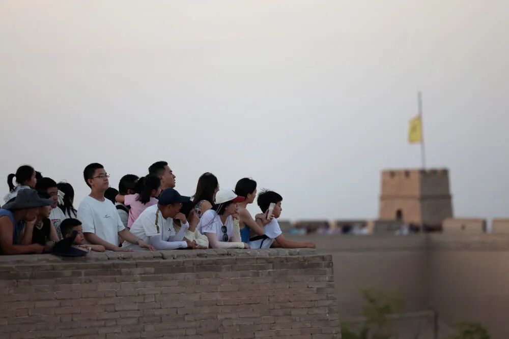8月5日,参加夜游的游客在嘉峪关关城等待亮灯、演出。