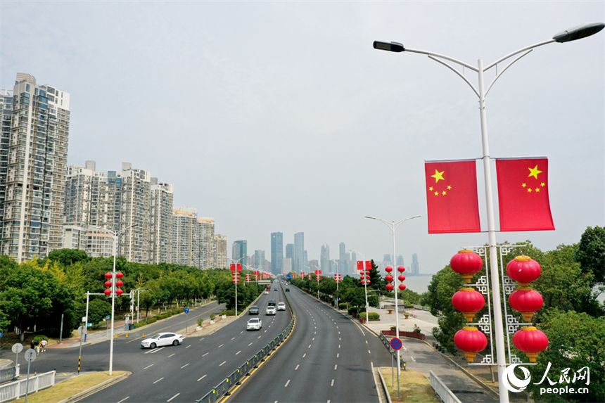 南昌市红谷滩区的道路两侧悬挂着崭新的国旗，城市洋溢着喜庆祥和的节日氛围。人民网记者 时雨摄