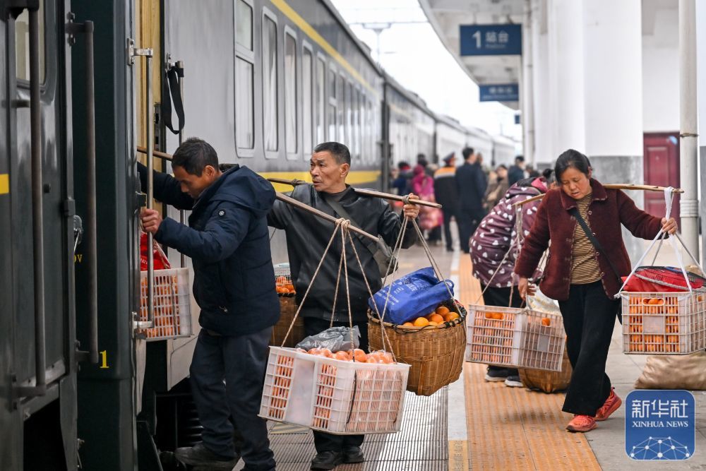 ↑ 2月12日,7272次公益性慢火车停靠在湖南省锦和站,菜农挑着新鲜果蔬准备乘车运往贵州铜仁销售。新华社发(袁福洪 摄)