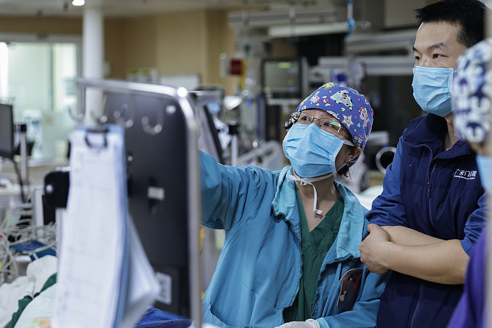 2月4日3时许，一名麻醉医生（左）和重症监护室医生交接患者病情。