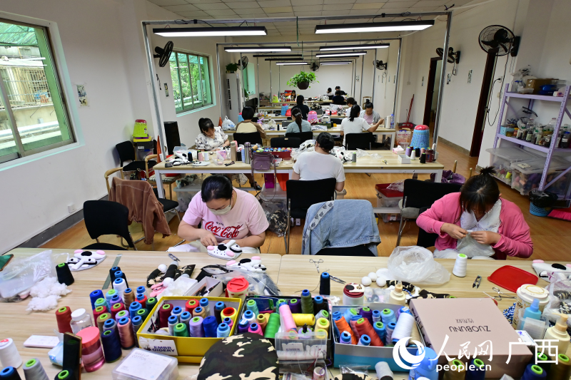 巧娘们正在缝制手工品。人民网记者 雷琦竣摄