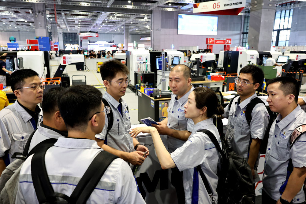 2026年9月24日，来自通用技术集团的产业工人在第48届世界技能大赛数控铣赛项现场外交流讨论。新华社记者 方喆 摄