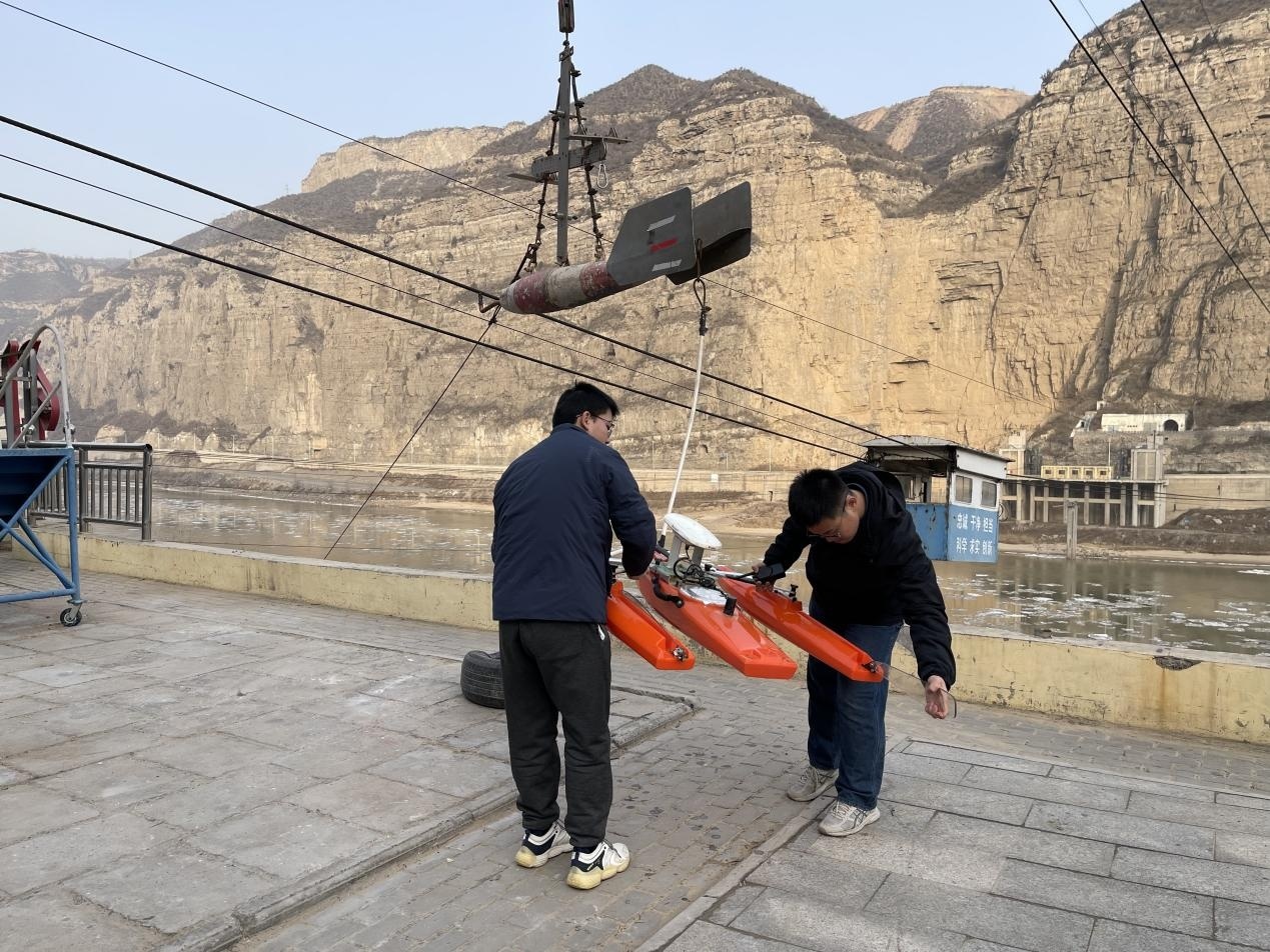 王子昂(右)正在与站内同事一起调试ADCP(记者江晓晨 摄)