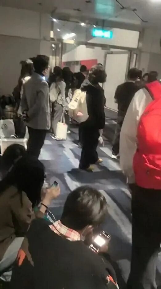 乘客们等待重新安检。(网络视频截图)