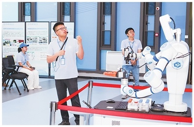 中国科学技术大学精准智能化学实验室科研人员在介绍实验设备。中国科学技术大学供图