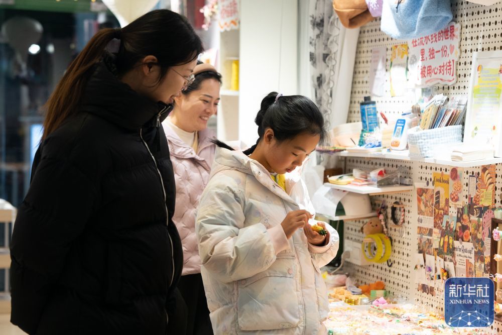 ↑ 1月10日，游客在合肥市新粮仓商业合集一家文创店内选购商品。