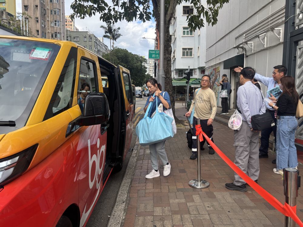 宏福苑受灾居民在庇护中心出来后，乘坐停靠在香港大埔社区会堂外的义载车辆（2025年12月2日摄）。新华社发（许淑敏摄）