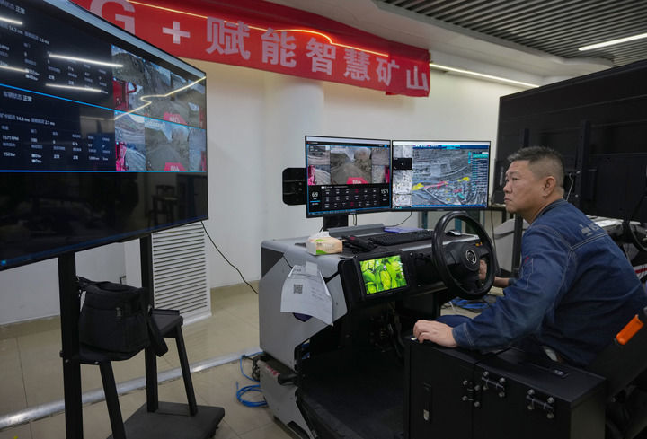 在位于四川攀枝花的攀钢集团矿业有限公司朱兰铁矿分公司5G操控大厅里,矿工坐在智控座舱中,通过5G网络远程操控矿山机械采矿(2025年7月9日摄)。新华社记者 江宏景 摄