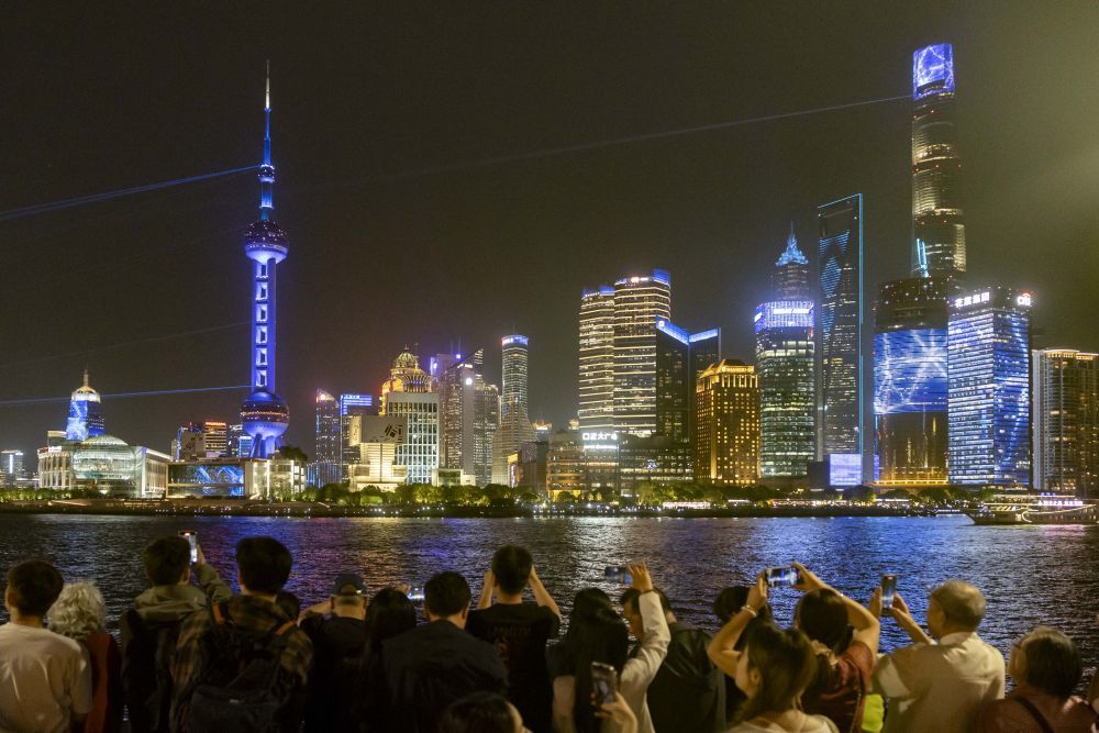 人们在上海外滩拍摄对岸陆家嘴庆祝浦东开发开放35周年光影秀(2025年4月17日摄)。新华社记者 王翔 摄