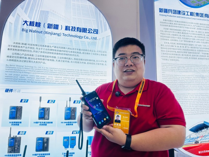 大核桃（新疆）科技有限公司总经理郑龙现正在向顾客展示可在无网络环境实现通讯的防爆智能手机。李萍   摄.jpg