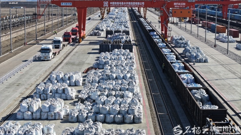 5月20日，阿拉山口站换15线上，机械设备腾挪码放整齐的袋装矿产品。宋玉龙摄