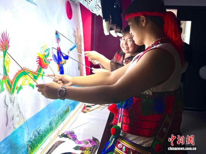 在沈阳市大东区素质教育学校，台湾少数民族同胞在体验皮影戏。杨茜茜 摄