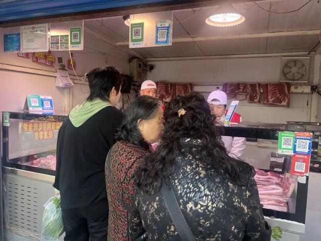 早市上市民正在购买猪肉。