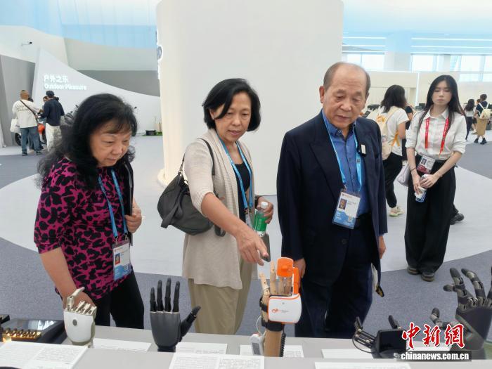 10月15日,89岁的香港采购商赵振邦(右)逛广交会展馆。中新社记者 蔡敏婕 摄