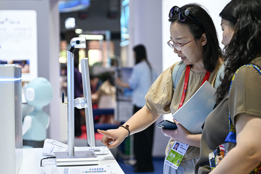 ↑ 4月14日，观众在第六届消博会孚宝智能展台体验AI心理筛查机器人。新华社记者 蒲晓旭 摄