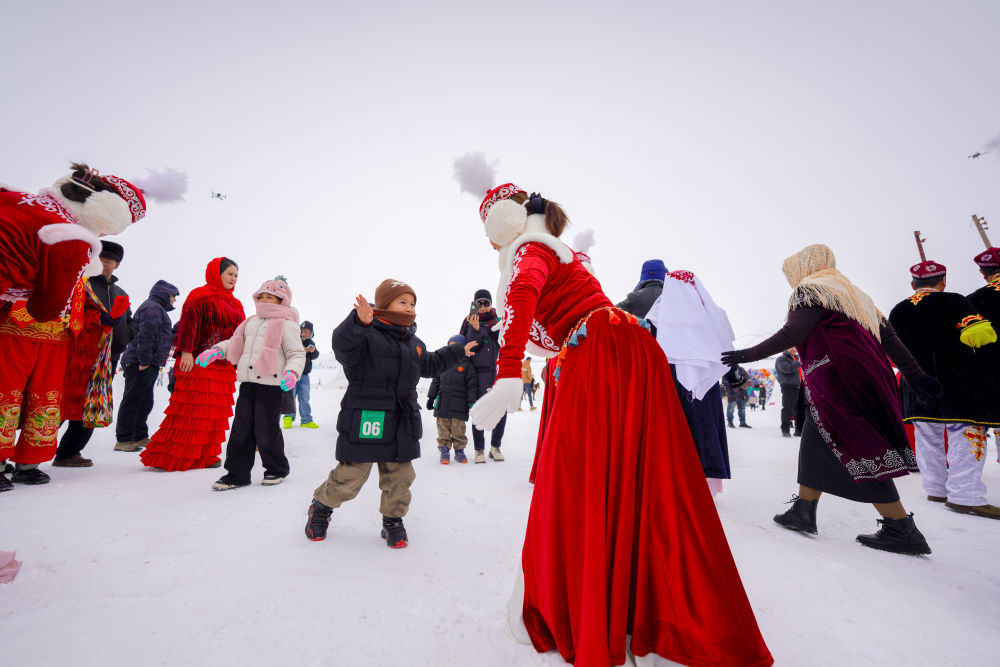 新疆昭苏县湿地公园，演员与游客共同跳舞。新华社记者 徐宏岩 摄
