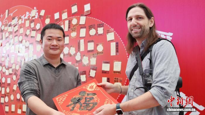 外国旅客获赠“福”字书法作品。卓悦 摄