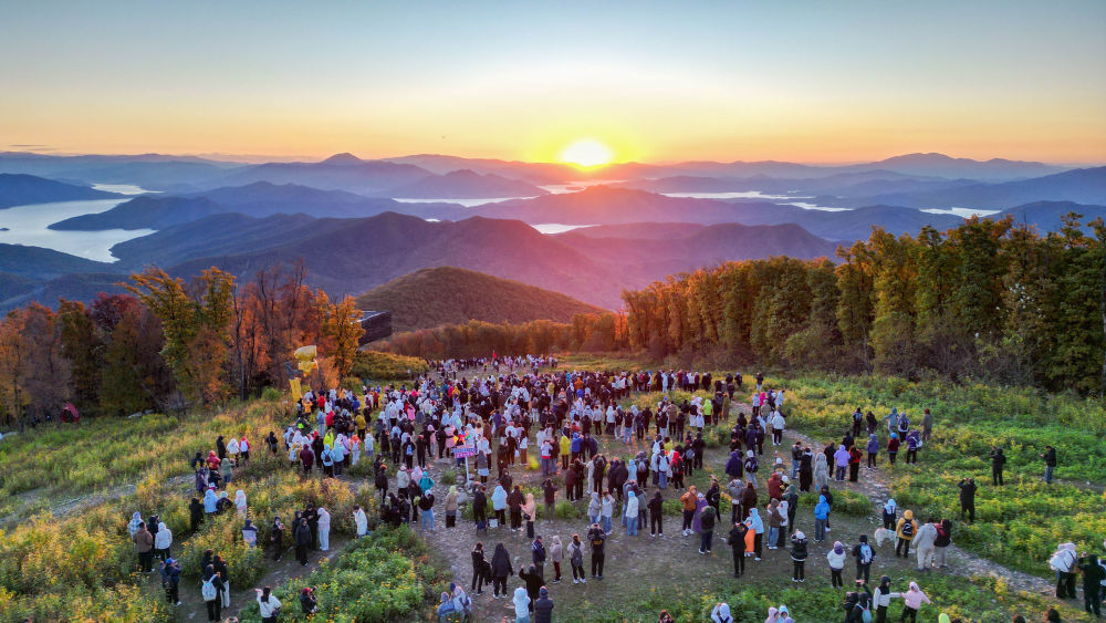 10月2日,游客在吉林省中旅松花湖度假区山顶观看日出。新华社记者 颜麟蕴 摄
