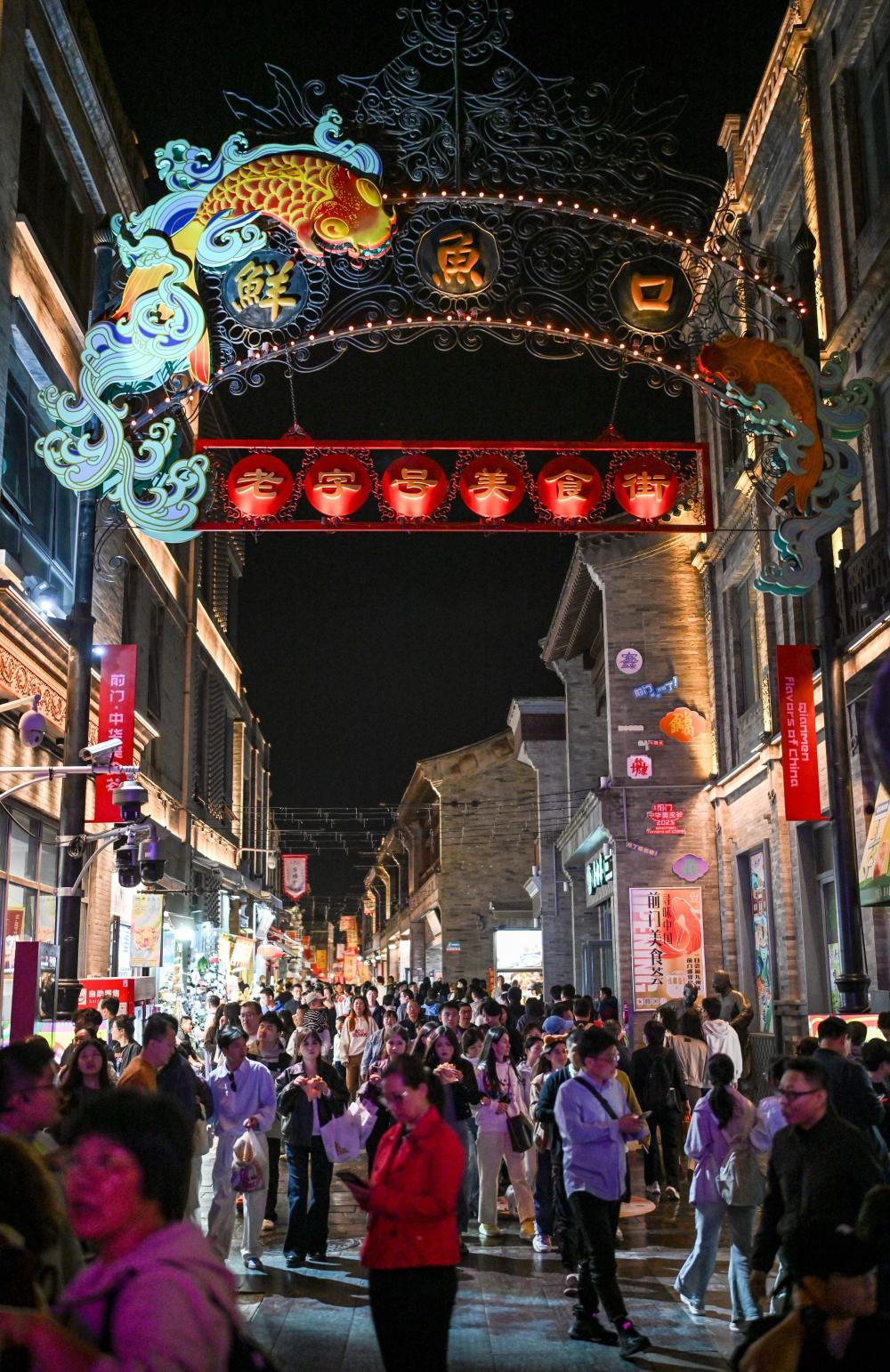 10月5日晚,游客在北京前门鲜鱼口美食街游览。 新华社记者 陈晔华 摄