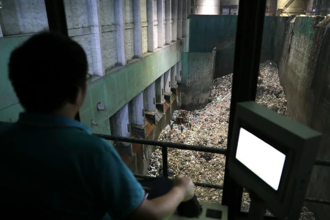 2024年6月29日,在江西南昌固废处理循环经济产业园,生活垃圾焚烧发电项目的工作人员通过操控垃圾吊移动垃圾/新华社记者 杜潇逸 摄