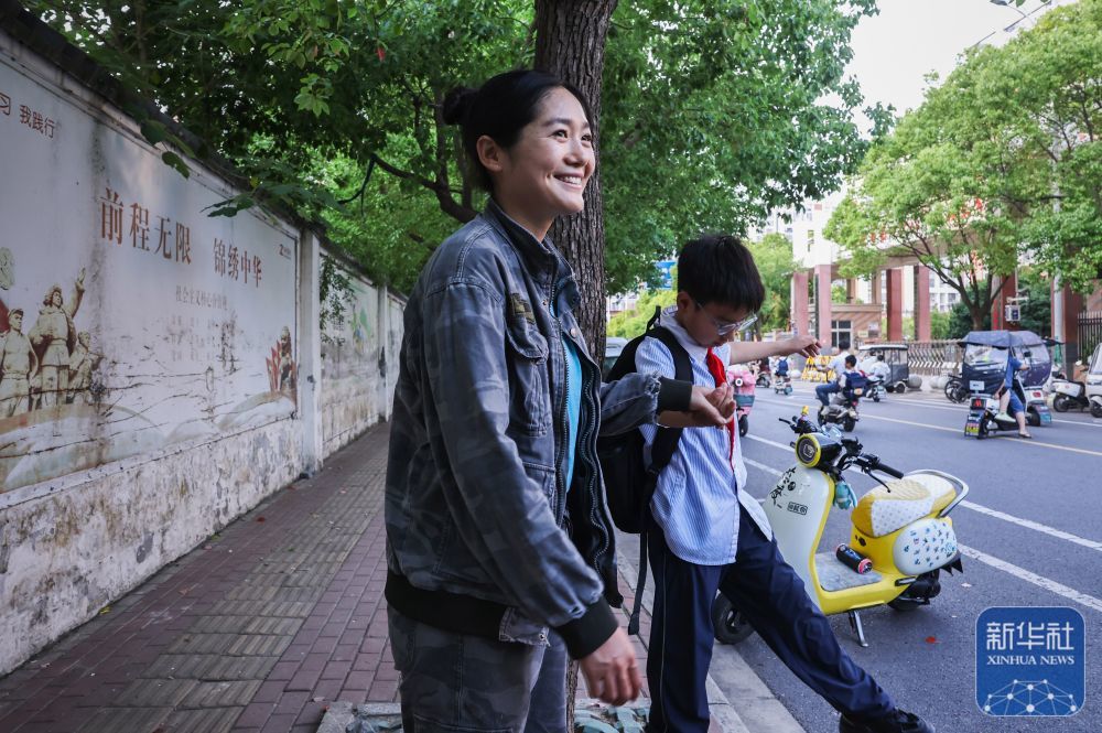 ↑6月2日，在安徽阜阳，梁洪美接孩子放学。
