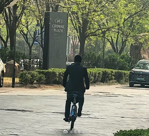 蔚来CEO李斌骑共享单车赶车展 街头大方和路人合影