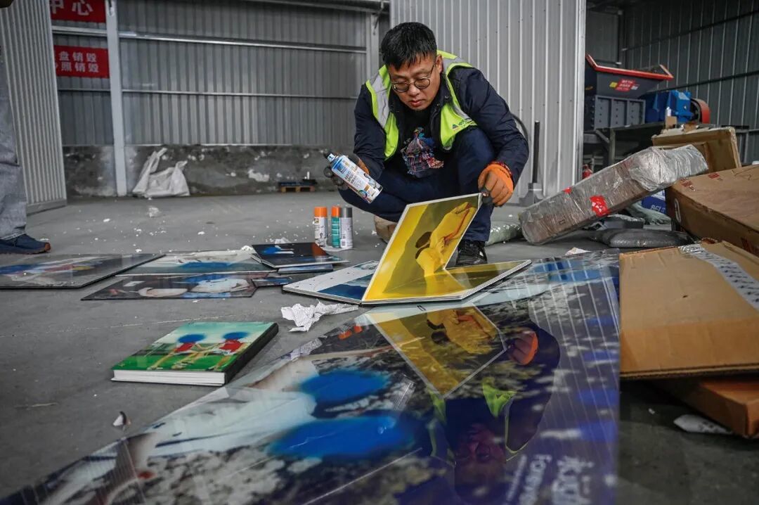 2024年3月27日,河北廊坊。离婚夫妻的婚纱照被喷漆销毁。这些婚姻破裂的夫妻,选择将回忆交给这个仓库。照片被放入工业粉碎机中,转化为电力资源。(图/CFP)