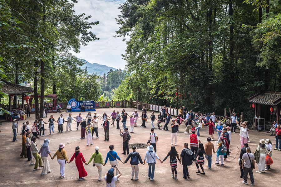 10月19日,在腾冲市清水镇三家村中寨司莫拉佤族村,游客与当地群众、演职人员一起打跳。