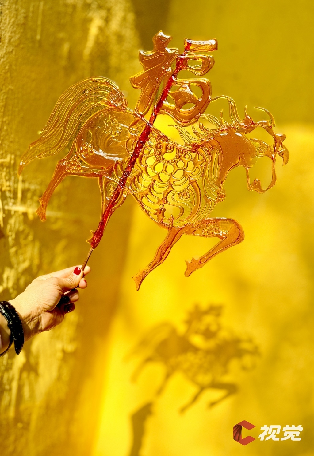 2月21日,成都市双流区彭镇老街,游客手持“马福”糖画,定格马年福气。