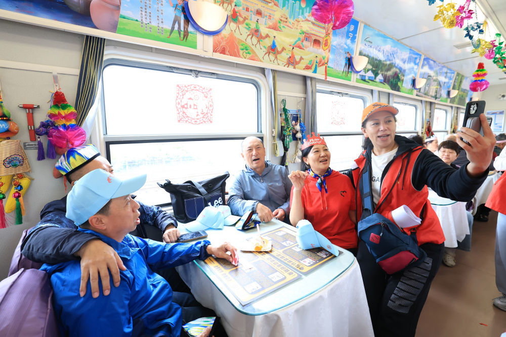 2025年5月21日,游客从哈尔滨东站出发,踏上开往新疆阿勒泰的Y64次“龙泰号”援疆银发旅游专列。新华社发(徐率摄)