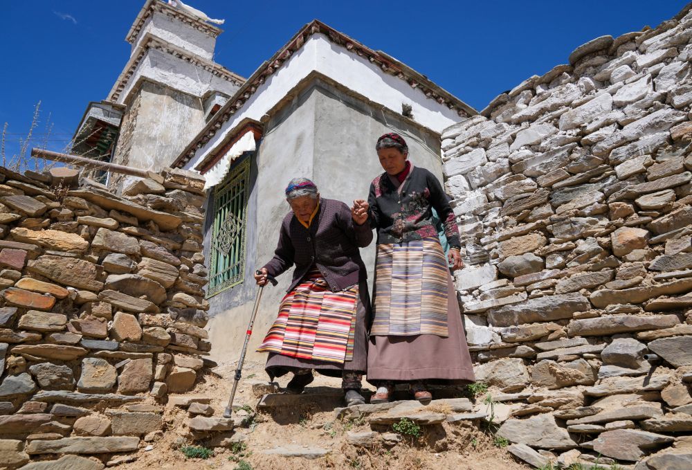 次仁桑姆(左)和女儿前去喂牛(3月26日摄)。