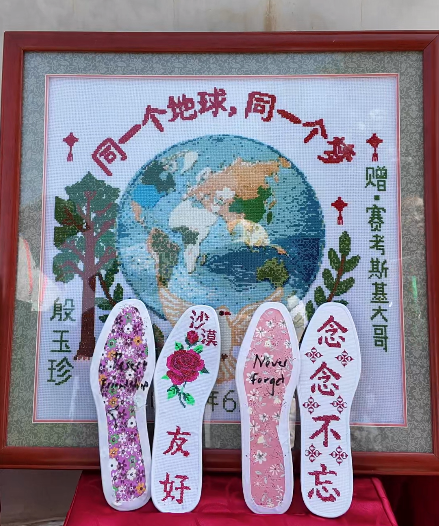 8月25日,殷玉珍为“赛考斯”送上亲手缝制的鞋垫和十字绣。人民日报记者 余星馨 摄