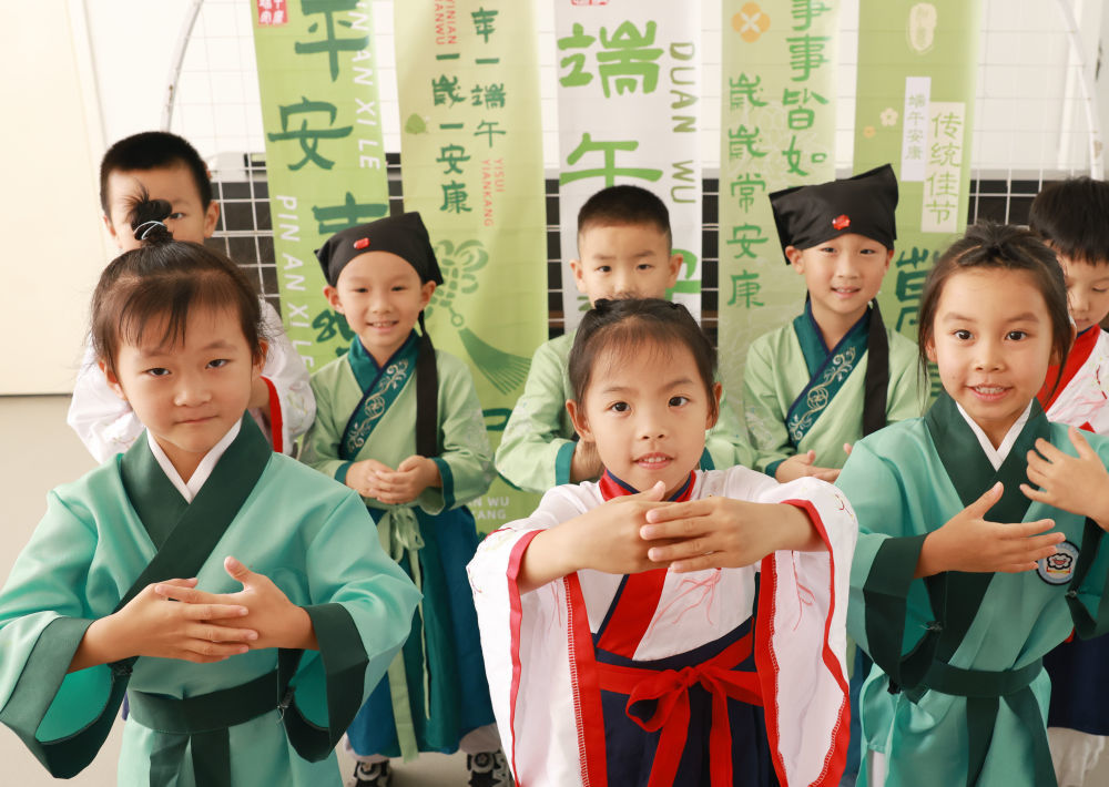 6月17日,湖北省武汉市江岸区百步亭快乐天使幼儿园小朋友体验“稚子习礼”传统文化。新华社发(赵军 摄)