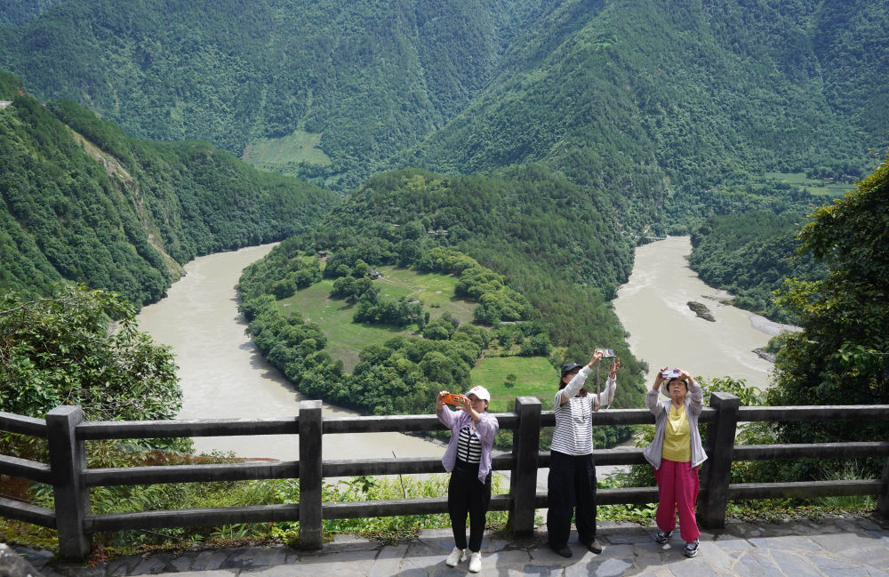 游客在云南省怒江傈僳族自治州贡山独龙族怒族自治县怒江第一湾拍照游玩（2025年7月15日摄）。新华社发（梁志强 摄）