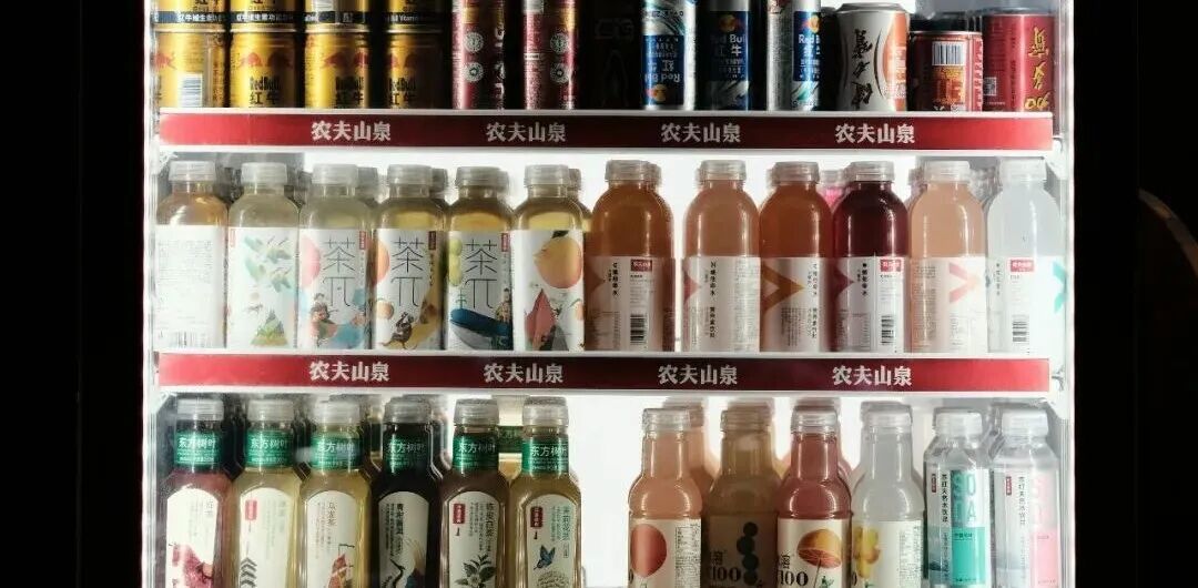 Refrigerated beverages are displayed on shelves in a store.