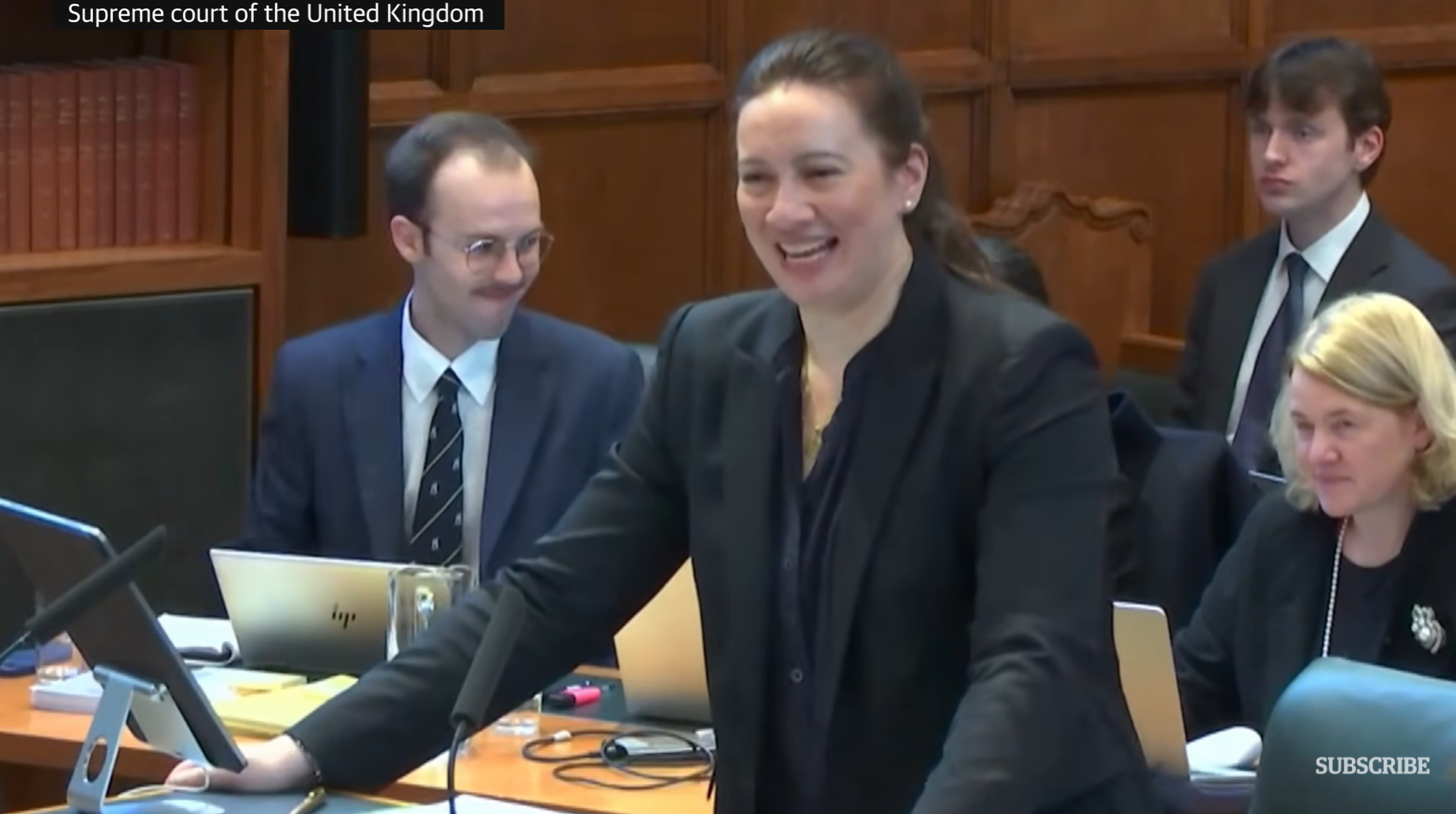 视频显示,随着音量越来越大,正在作陈述的法律专业人士笑了起来。图源:英国《卫报》视频截图