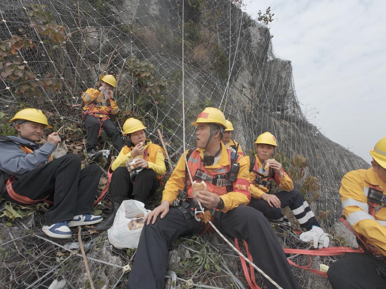 杨发登和队员在崖壁岩石上吃午餐