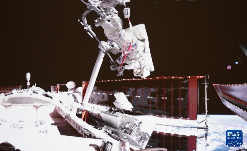 这是2025年5月22日在北京航天飞行控制中心屏幕上拍摄的神舟二十号航天员陈冬在空间站组合体舱外工作的画面。新华社记者 厉彦辰 摄
