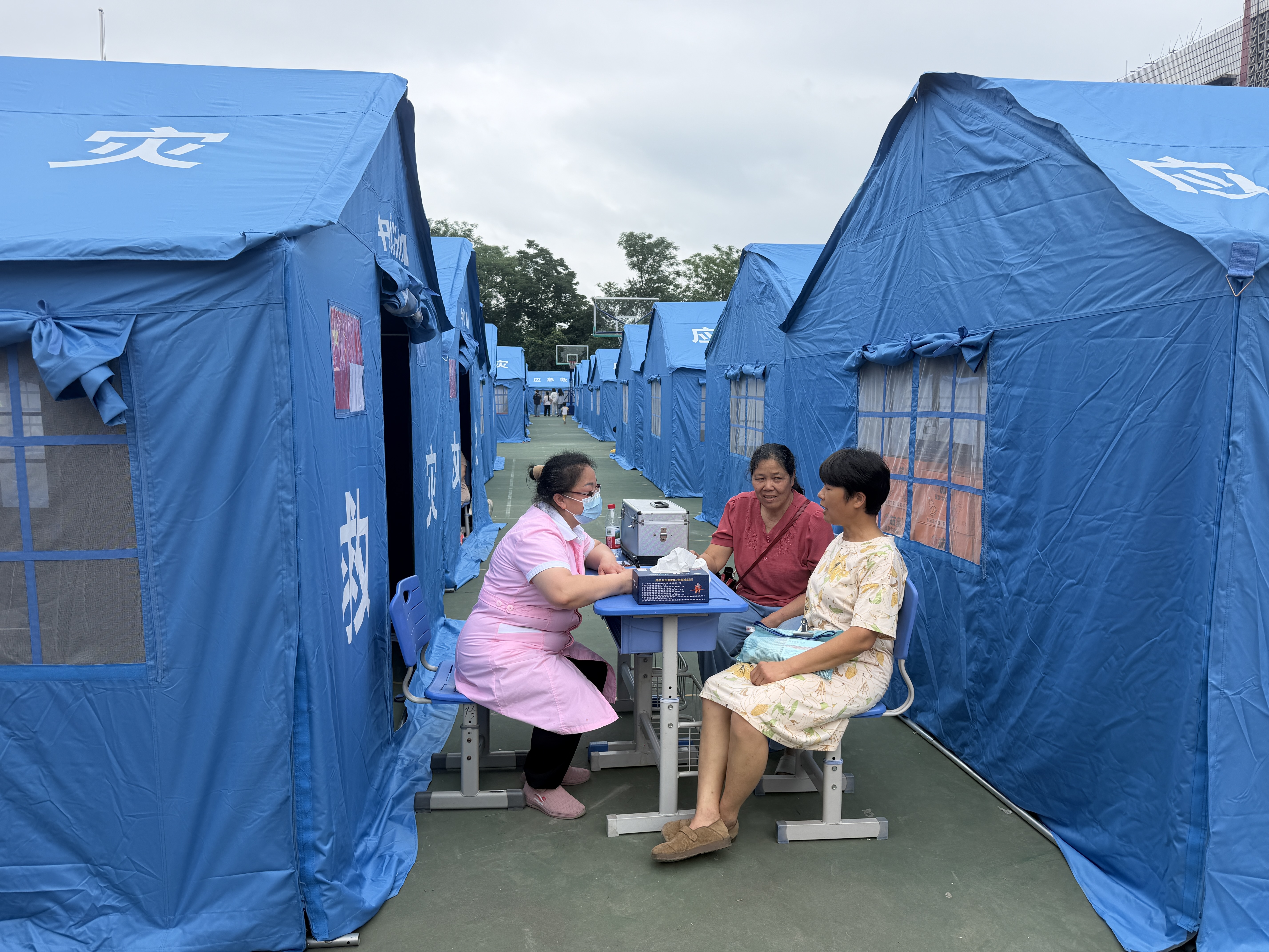 在太阳村中心校安置点,医护人员与居民沟通健康情况。新华社记者 农冠斌 摄