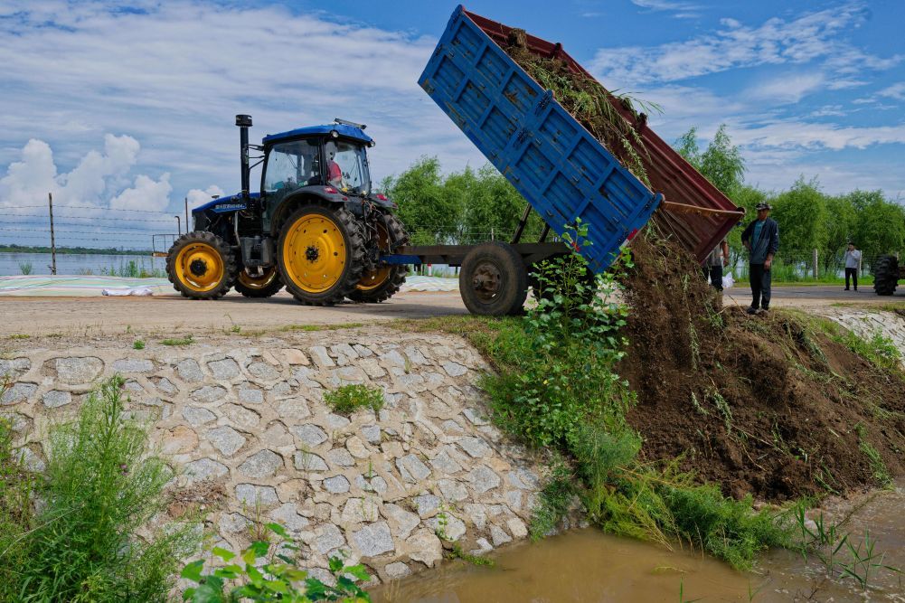 8月5日，村民在黑龙江同江市滨江路附近利用土方封堵管道防止进水。新华社记者 张涛 摄